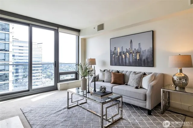a living room with furniture and floor to ceiling windows