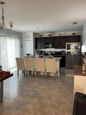 a dining hall with stainless steel appliances a table and chairs