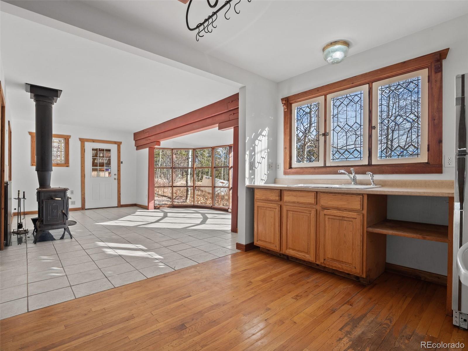 757 Lower Travis Gulch Road Black Hawk, CO 80422 - Photo 10 of 31 a large white kitchen with sink and dishwasher with wooden floor