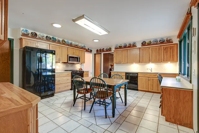 a kitchen with stainless steel appliances kitchen island granite countertop a refrigerator and a stove top oven