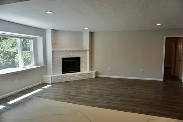 a kitchen with stainless steel appliances wooden floors and white walls