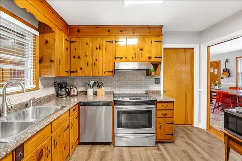 a kitchen with stainless steel appliances granite countertop a stove a sink and a refrigerator