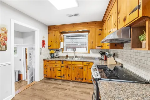 a kitchen with stainless steel appliances granite countertop a sink and a refrigerator
