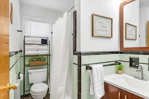 a bathroom with a granite countertop sink mirror vanity and toilet