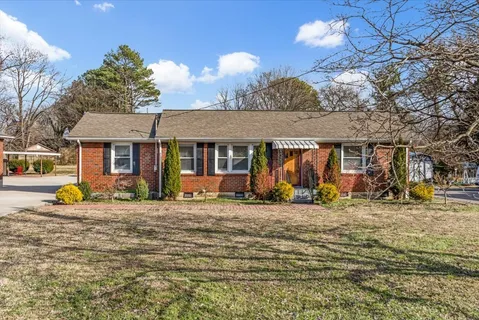 a view of a house with large outdoor space and a car parked in front of it