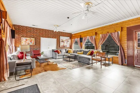 a living room with patio furniture and a large window