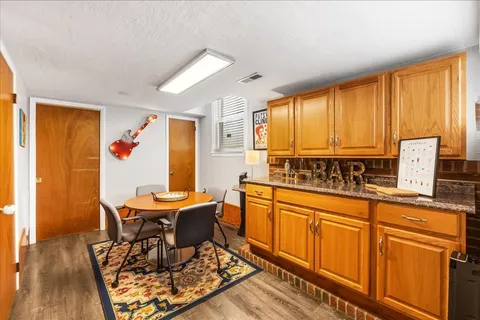 a view of a kitchen area with furniture and wooden floor