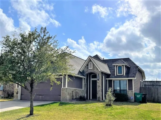 a front view of a house with a yard and a fountain