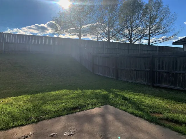 a view of a house with a yard and wooden fence