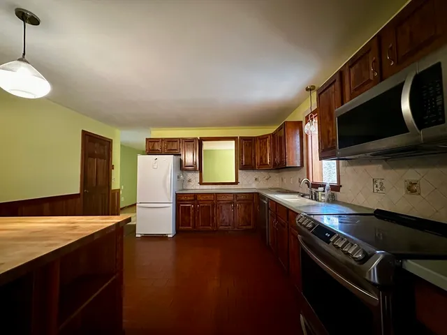 a kitchen with stainless steel appliances a sink dishwasher a stove and a microwave oven