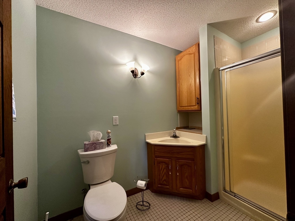 46 Swan Point Road Rindge, NH 03461 - Photo 20 of 42 a bathroom with a granite countertop toilet sink and mirror