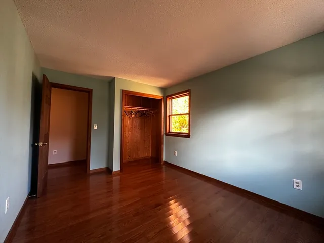 an empty room with wooden floor and closet