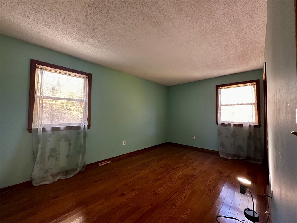 46 Swan Point Road Rindge, NH 03461 - Photo 29 of 42 an empty room with wooden floor and windows
