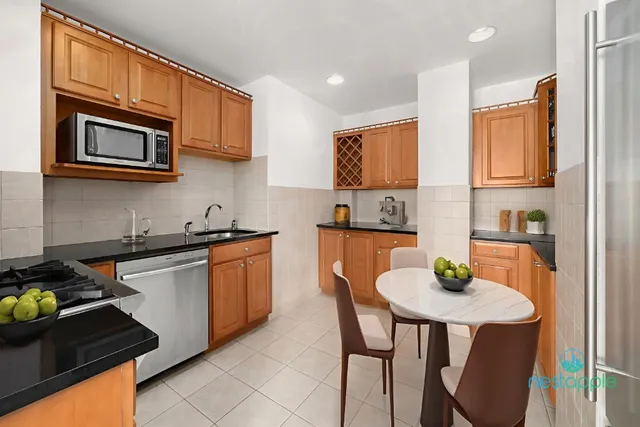 a kitchen with stainless steel appliances granite countertop a stove a microwave a sink and cabinets