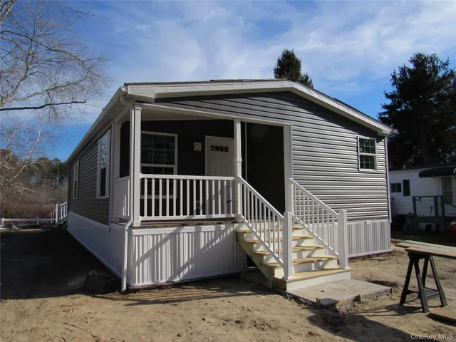 a view of a house with a small yard and wooden fence