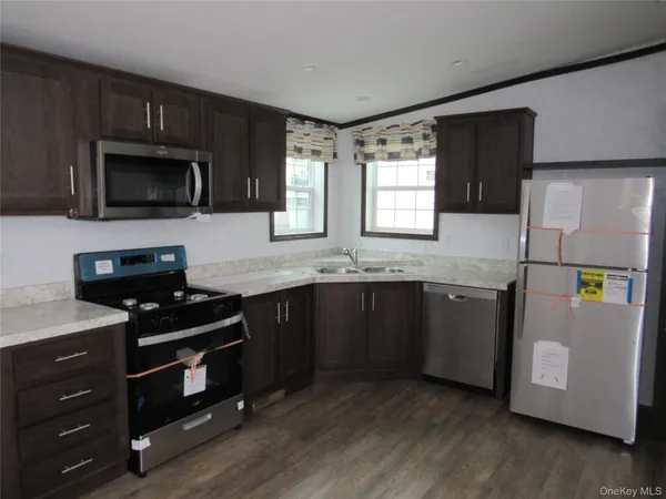 a kitchen with granite countertop cabinets stainless steel appliances and a counter space