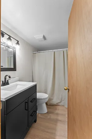 a bathroom with a sink a toilet and a mirror