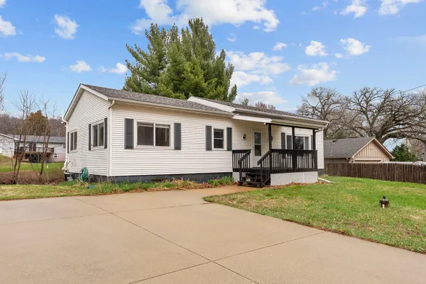 a front view of a house with a yard and trees