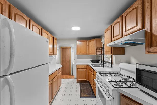 a kitchen with stainless steel appliances granite countertop a refrigerator a stove and a sink