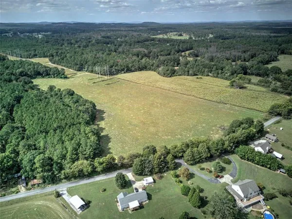 an aerial view of residential houses with outdoor space and trees