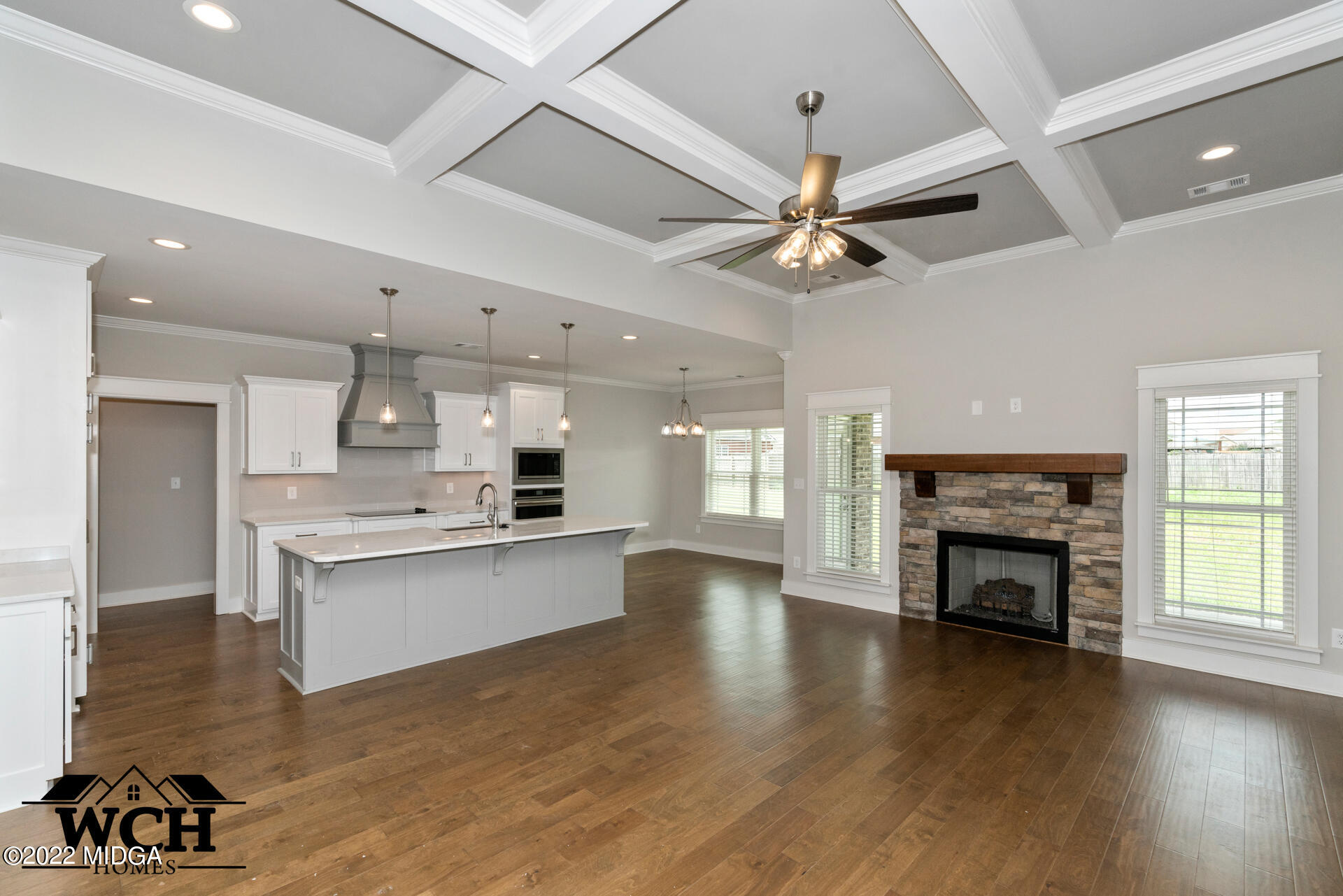 107 Perth Court Warner Robins, GA 31088 - Photo 11 of 27 a open kitchen with a fireplace cabinets and a wooden floor