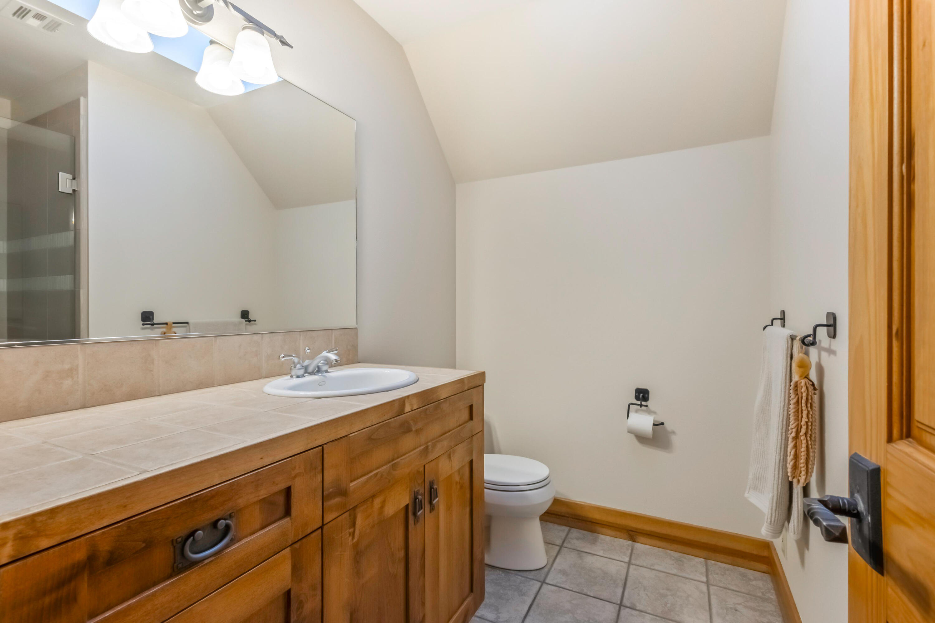 69590 Omaha Road Sisters, OR 97759 - Photo 24 of 46 a bathroom with a granite countertop sink mirror vanity and toilet