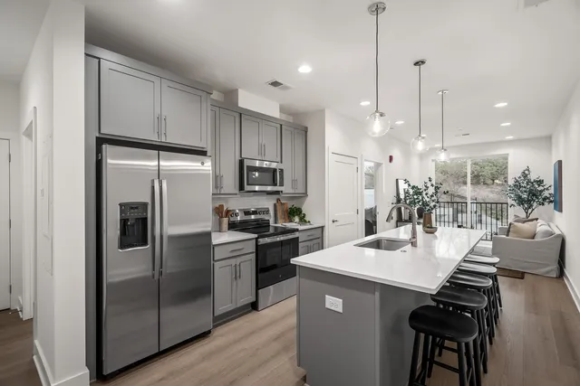 a kitchen with counter top space a sink stainless steel appliances and cabinets