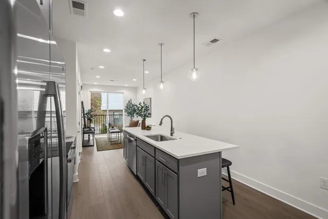 a bathroom with a sink a potted plant and wooden floor