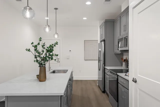 a kitchen that has a lot of cabinets a sink and a refrigerator
