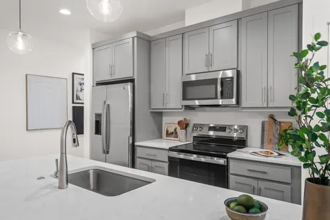 a kitchen with a sink a stove and cabinets