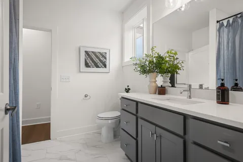 a bathroom with a toilet sink and mirror