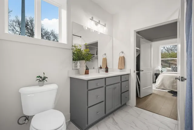 a bathroom with a toilet sink and mirror