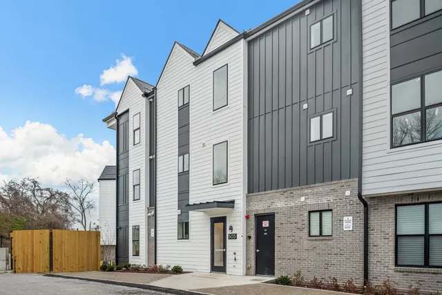 a view of a house with large windows and potted plants