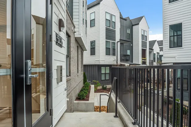a kitchen with a refrigerator a stove a sink a dining table and chairs