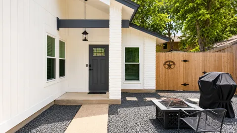 a backyard of a house with glass top table and chairs