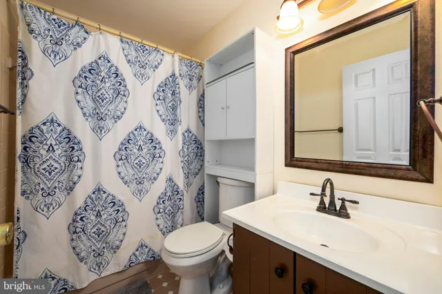 a bathroom with a sink and mirror with toilet