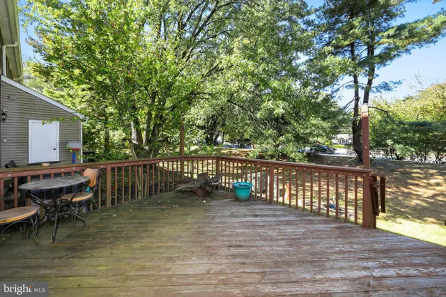 a balcony with wooden floor table and chairs
