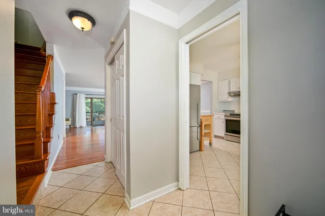 a view of a hallway with wooden floor and a living room