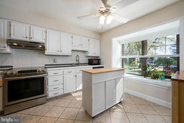 a kitchen with a stove sink and cabinets