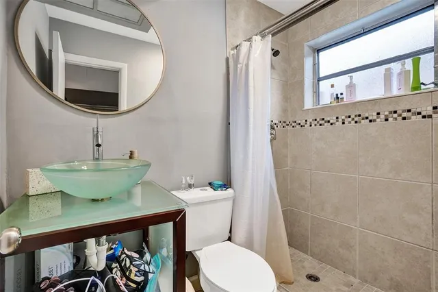 a bathroom with a toilet a sink and a mirror