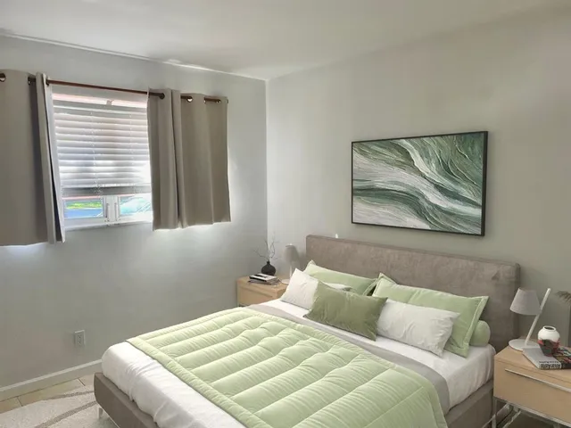 a bedroom with a bed and a painting on the wall