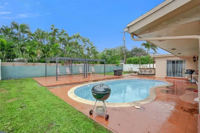 a swimming pool with outdoor seating and yard