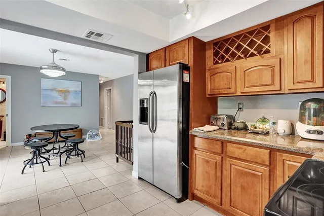 a kitchen with stainless steel appliances granite countertop a refrigerator and a stove top oven