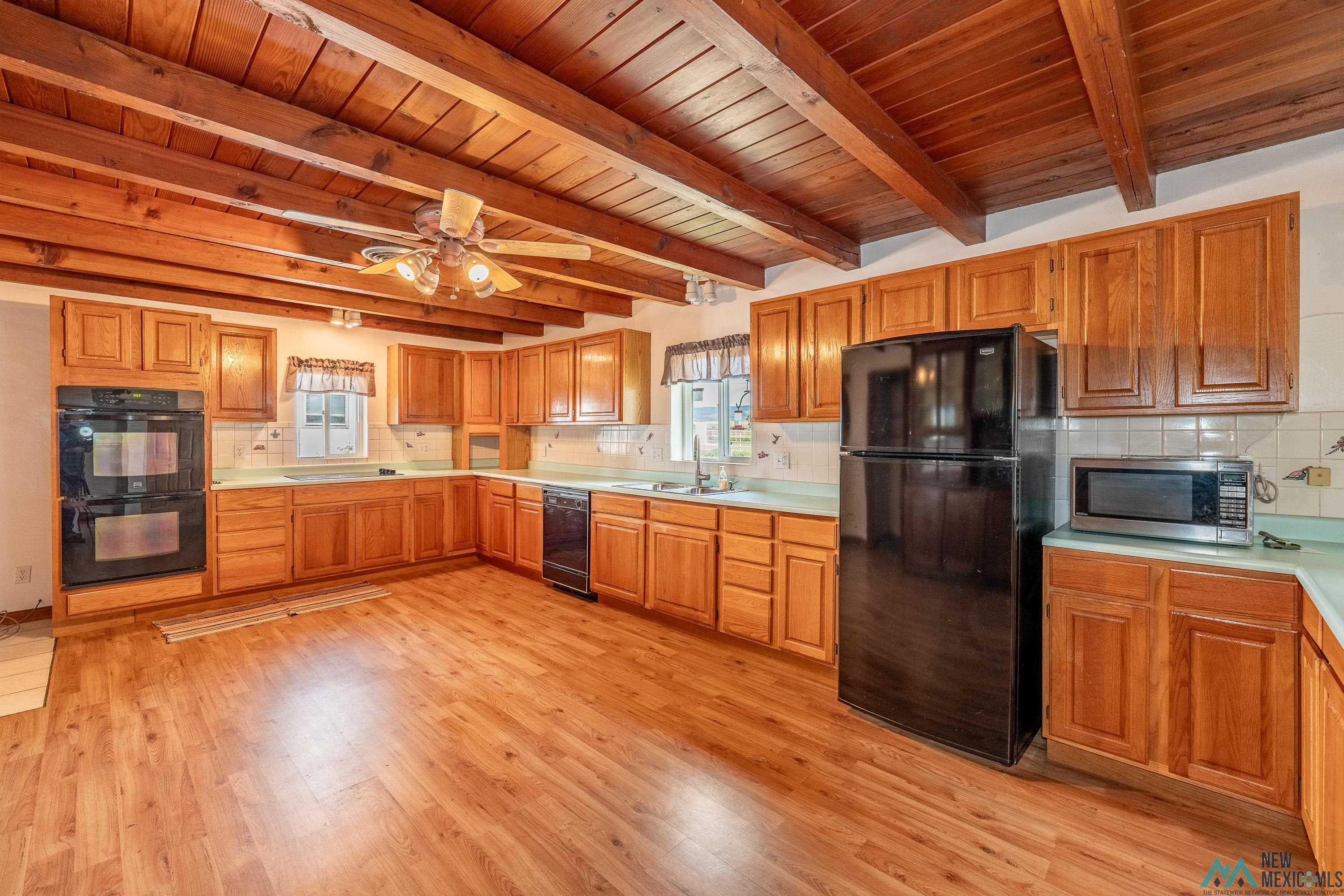 35234 Highway 87 Raton, NM 87740 - Photo 12 of 90 Kitchen with tasteful backsplash, black appliances, light countertops, ceiling fan, and a wooden ceiling with exposed beams