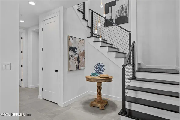 a living room with furniture and a large window with potted plants
