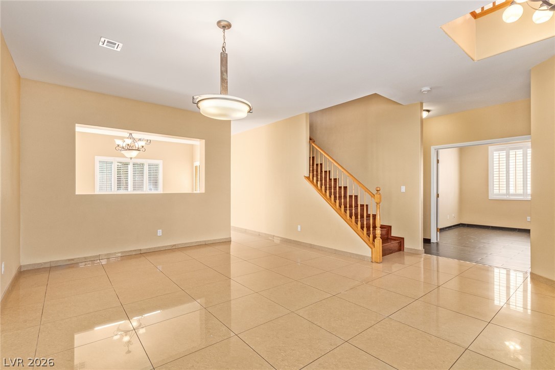 1477 Rancho Ridge Drive Henderson, NV 89012 - Photo 4 of 46 A grand staircase and smooth tile floors welcome you into this generously proportioned living space.