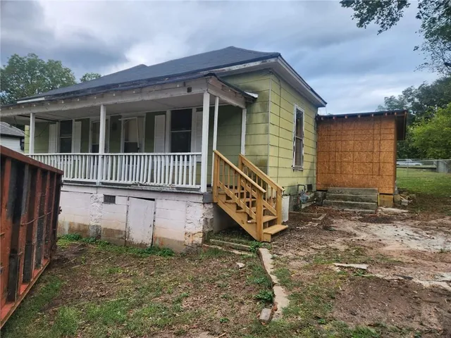 a view of a house with a yard and wooden fence