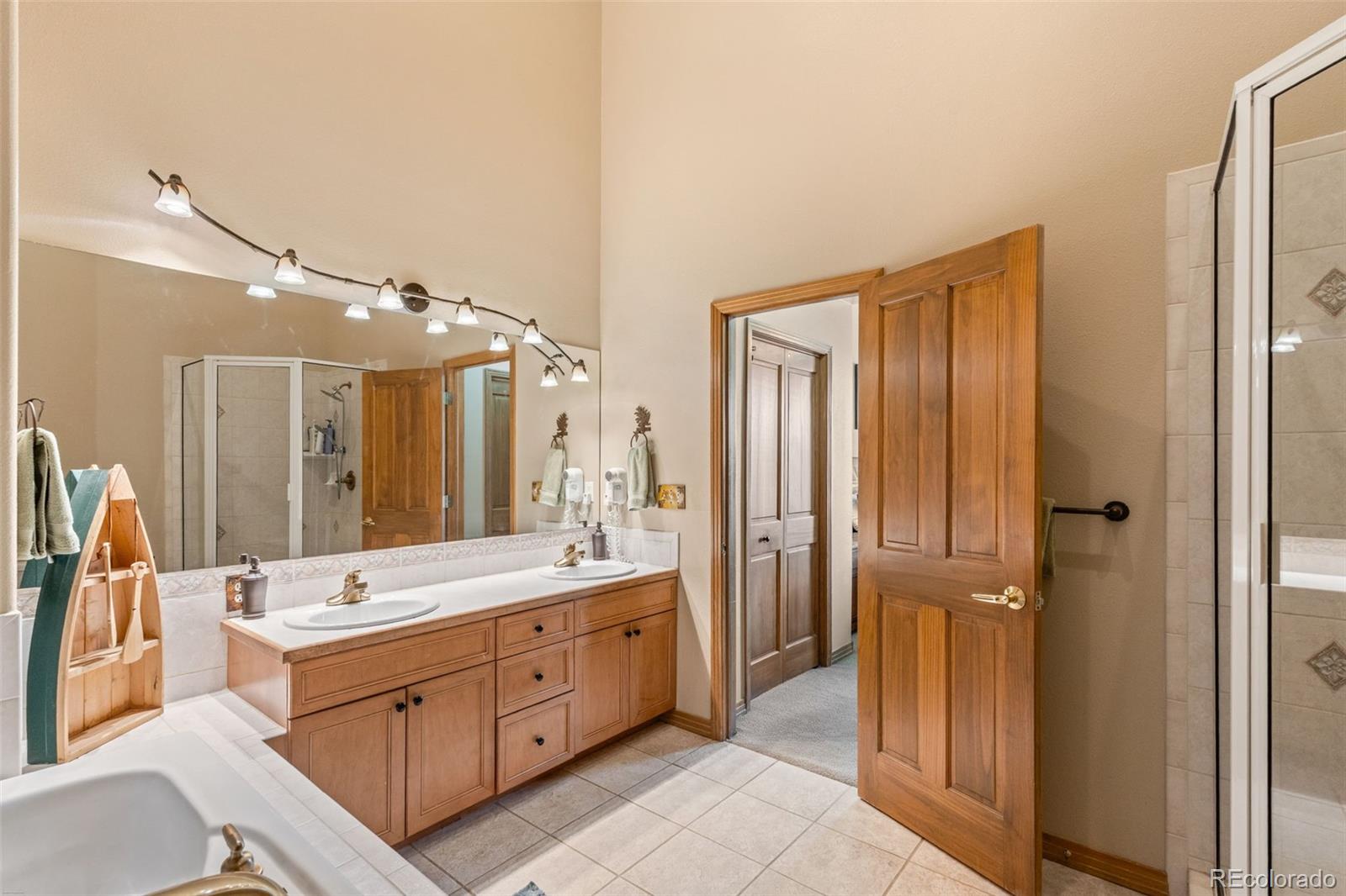 92 Emmett Lode Road, Unit B Breckenridge, CO 80424 - Photo 20 of 50 a spacious bathroom with a double vanity sink a large mirror and a shower