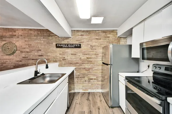 a kitchen with stainless steel appliances a sink stove and refrigerator