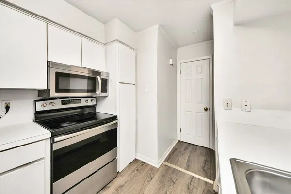 a kitchen with wooden floor and a stove top oven